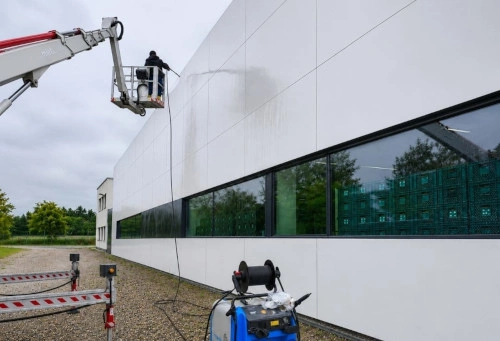 Eine Aussenfassade wird von einem Kran von aussen gereinigt.