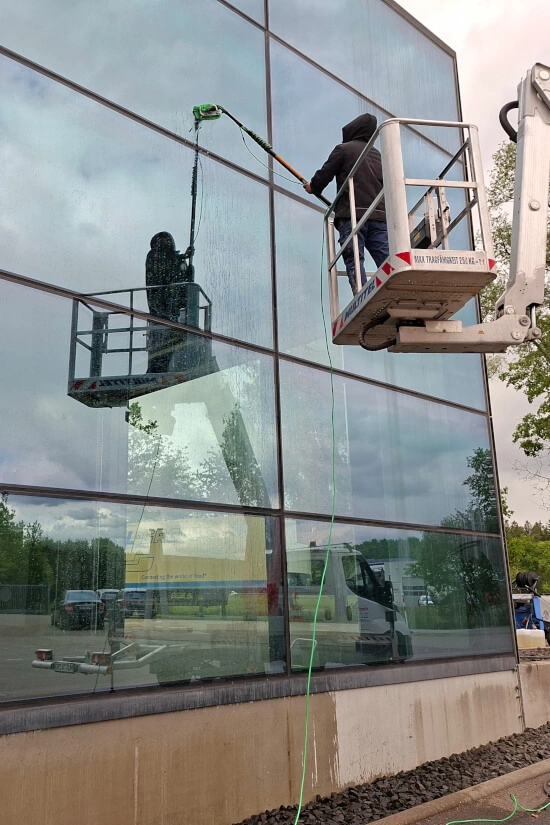 Ein Fensterreiniger reinigt eine Glas-Außenfassade in Laupheim
